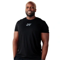 A smiling man with a beard stands wearing a black t-shirt with a white logo on the chest, against a plain white background. JW Training and Development