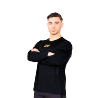 A person with short hair wearing a black long-sleeve shirt stands with arms crossed, facing forward against a white background. JW Training and Development