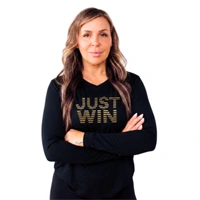 A woman with long, wavy hair stands with arms crossed, wearing a black shirt that says JUST WIN in gold letters. The background is white. JW Training and Development