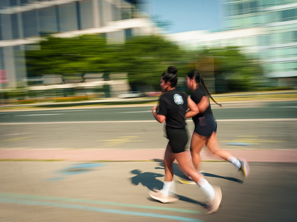 two female athletes running together with the JW Training & Development team